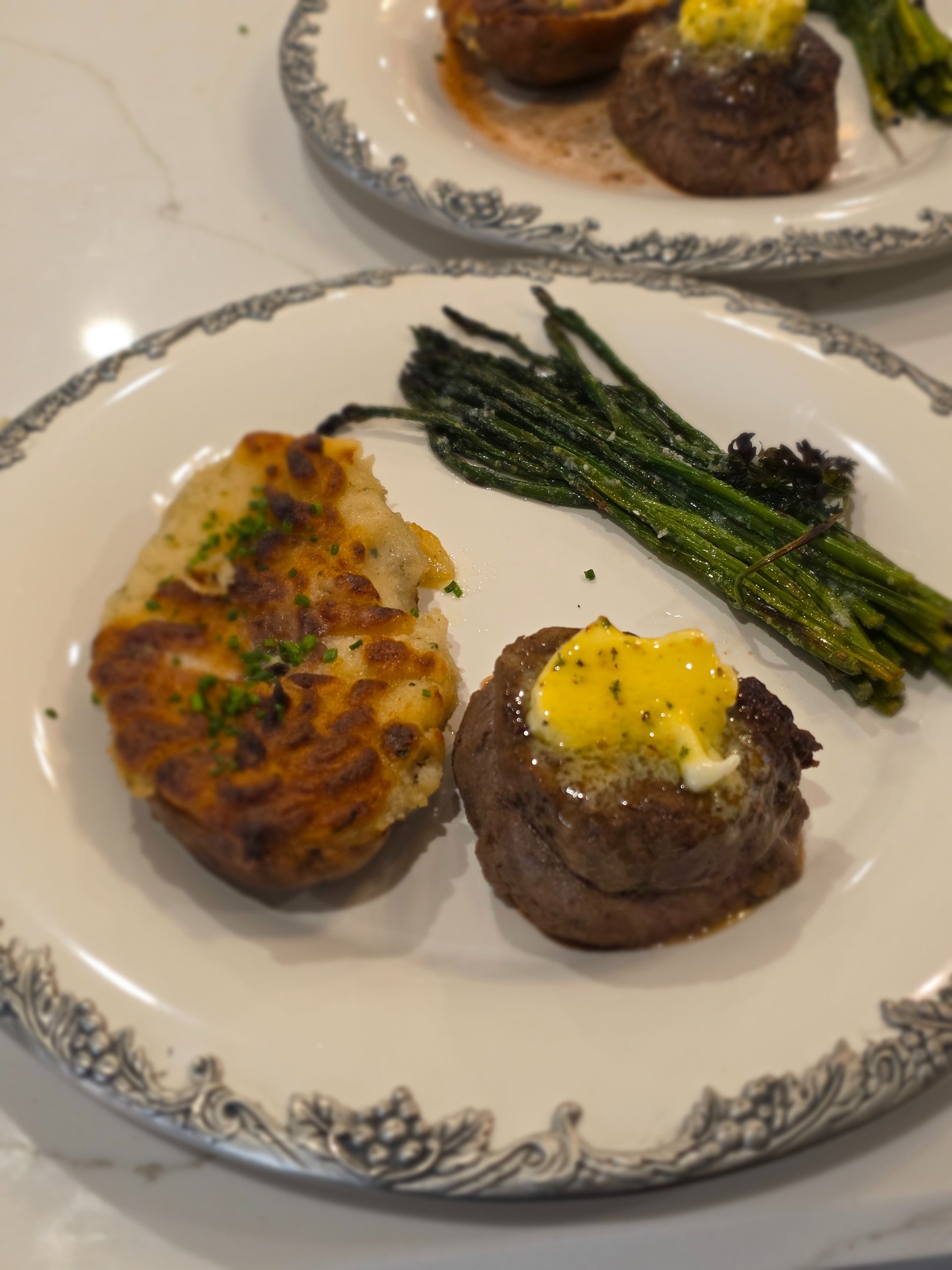 Plated steak with asparagus and a baked potato from Chef Joe’s culinary portfolio
